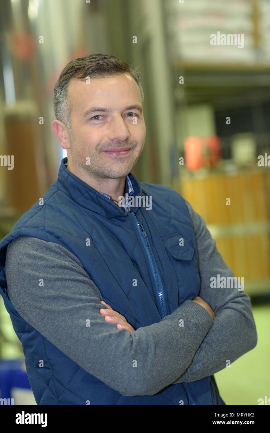 warehouse worker smiling at camera with arms crossed Stock Photo - Alamy