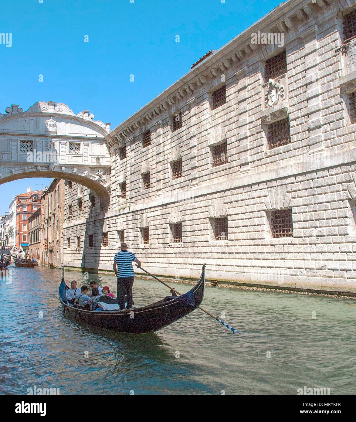 a-gondola-passes-under-the-bridge-of-sighs-in-venice-italy-stock-photo