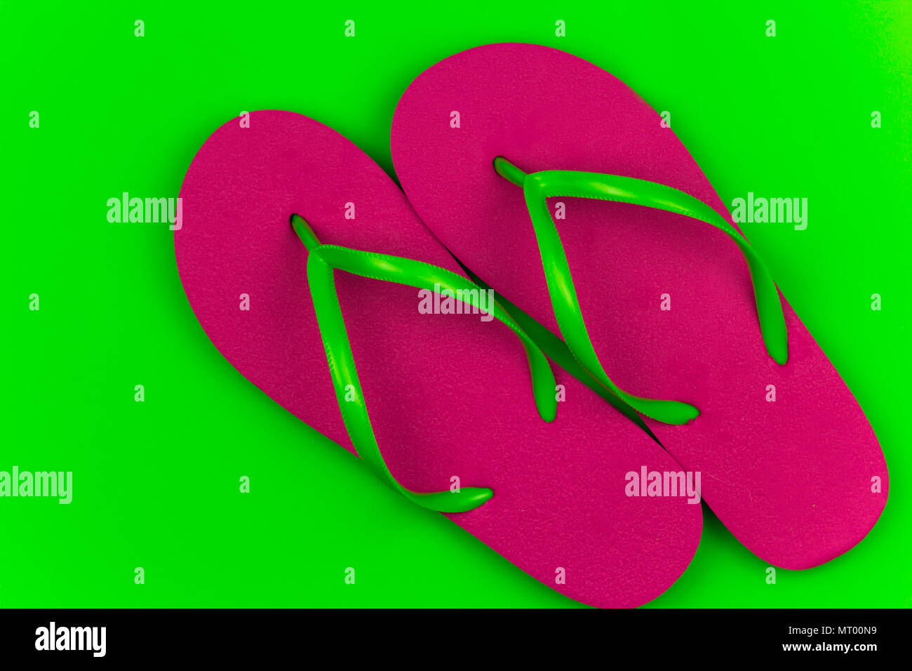 summer bright pink flip flops green background Stock Photo - Alamy