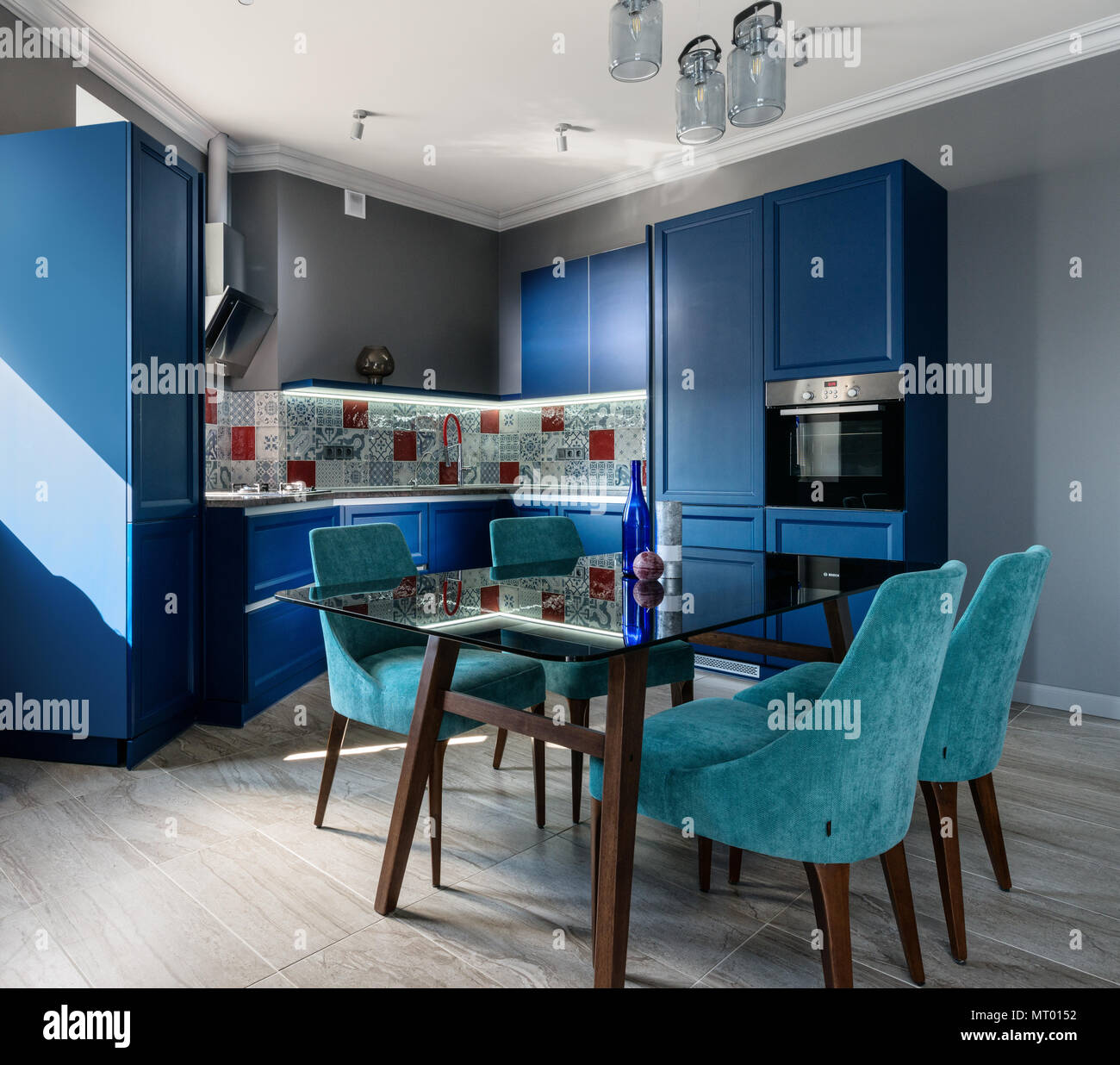 Modern blue kitchen, studio with dining table Stock Photo - Alamy