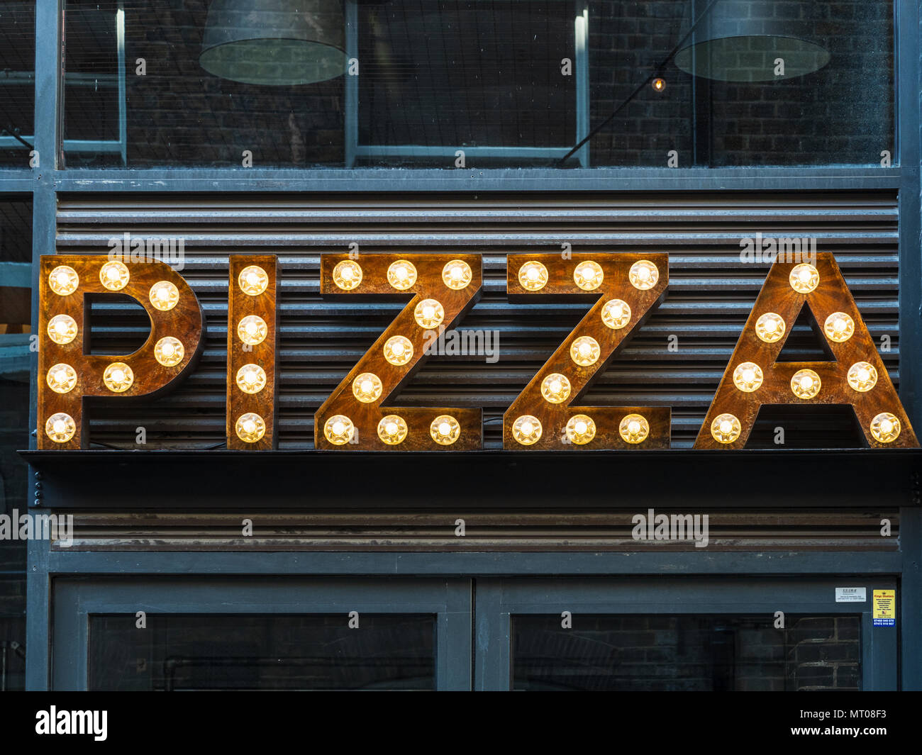 Pizza Sign Lights - an illuminated Pizza sign outside a restaurant in London's Shoreditch area Stock Photo
