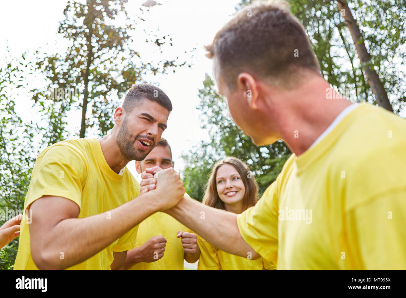 Young people at a sports festival make arm wrestling and train their strength Stock Photo