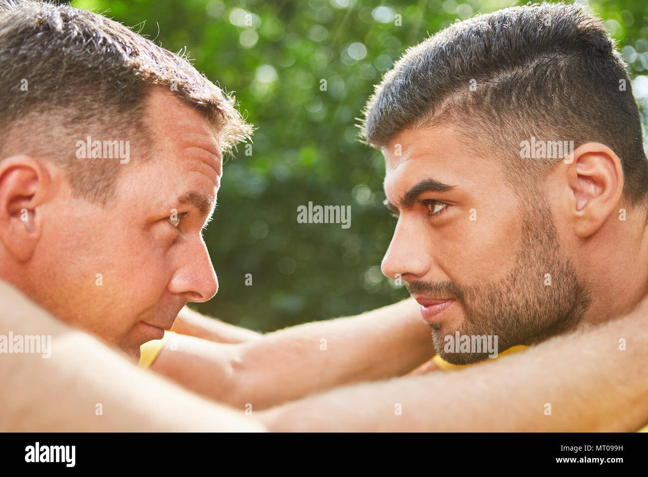 Two young men are doing an exercise for team development and looking at each other Stock Photo