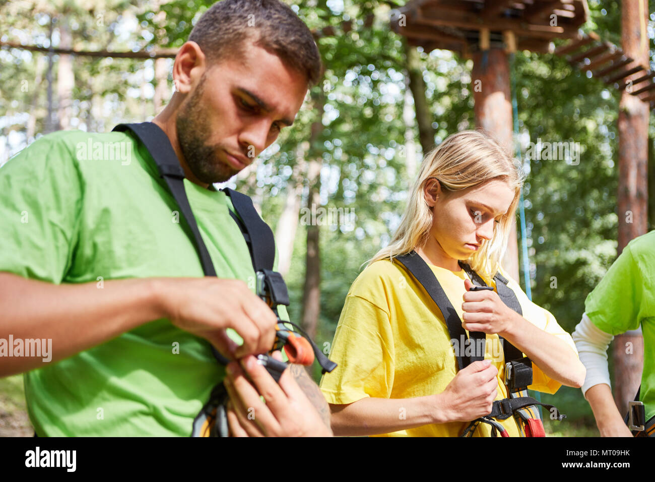 Young people in the beginner course for sport climbing fasten their harness Stock Photo
