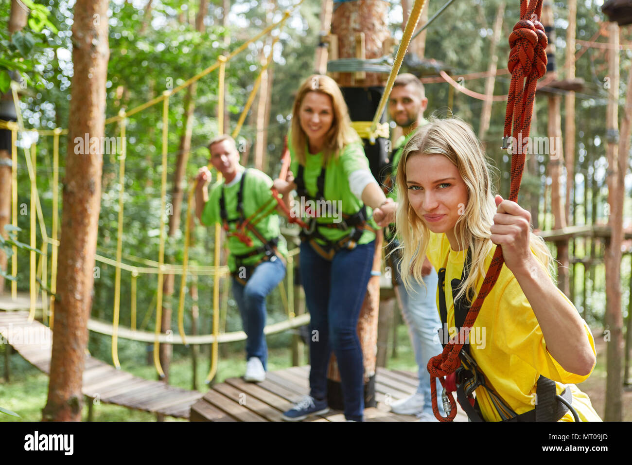 Women in the team help out in the high ropes course at the team ...