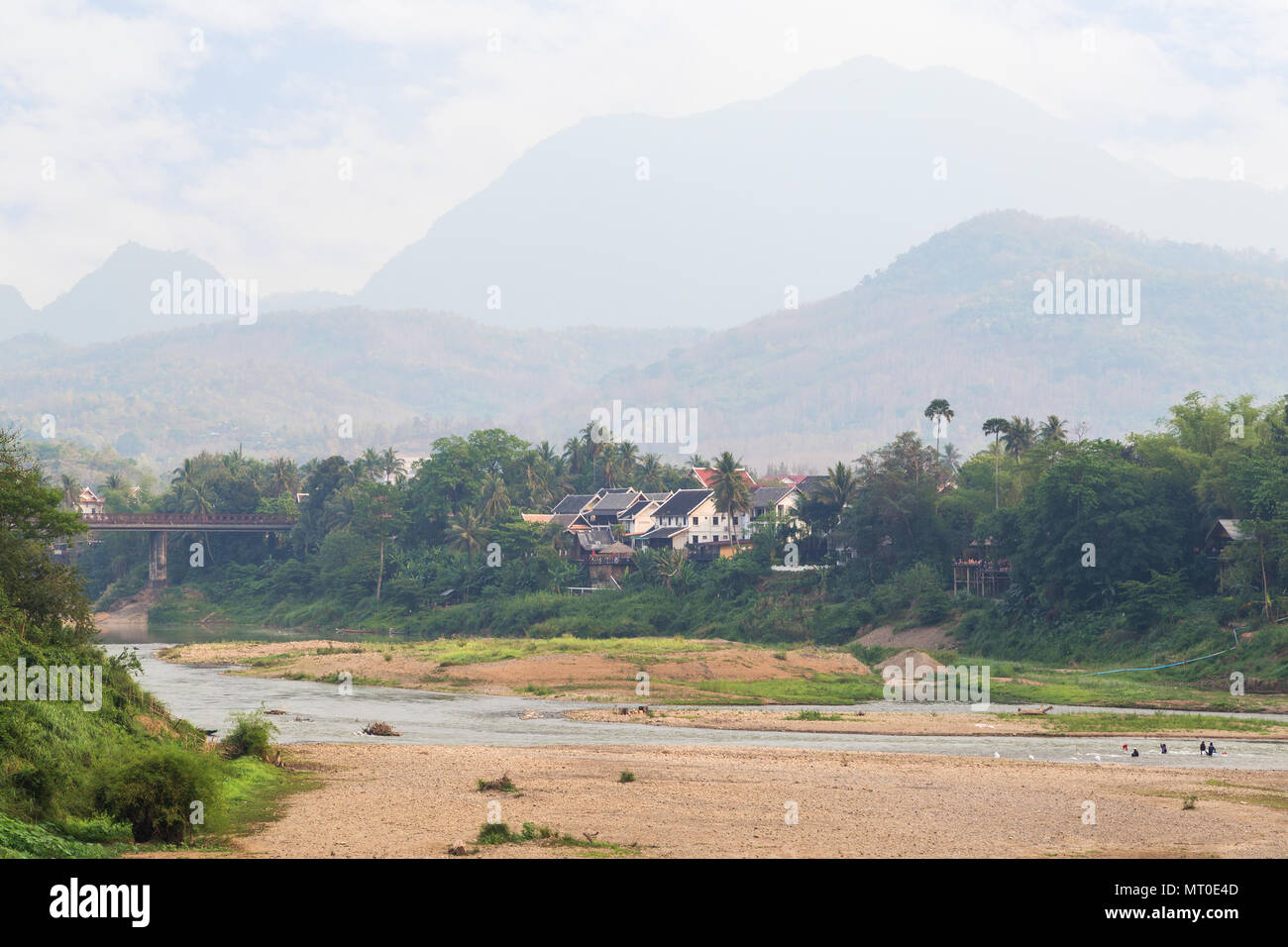View of Nam Khan River at low tide and lush riverbank in Luang Prabang, Laos, on a sunny day. Stock Photo