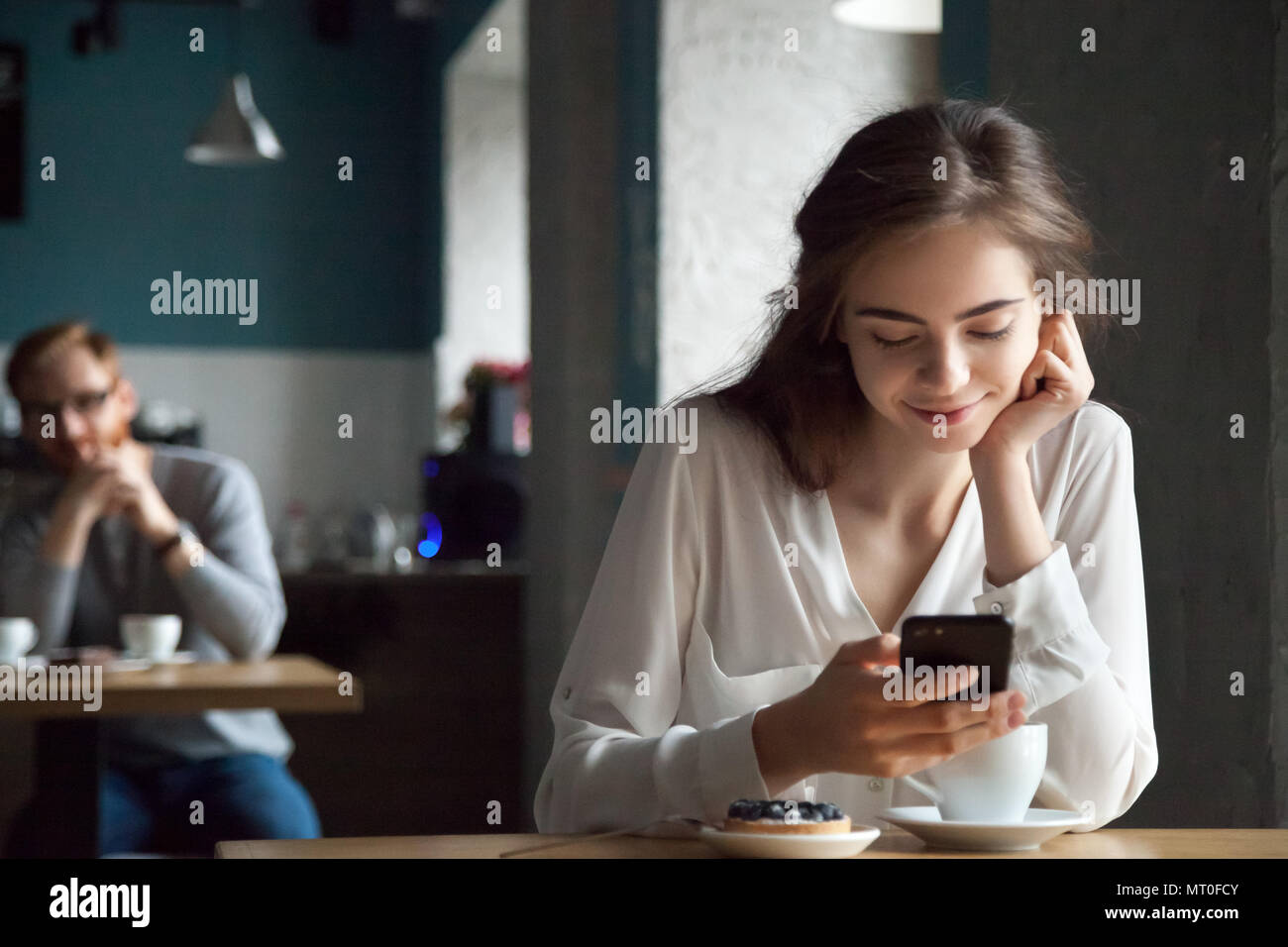 Young guy looking with interest at beautiful lady in cafe  Stock Photo