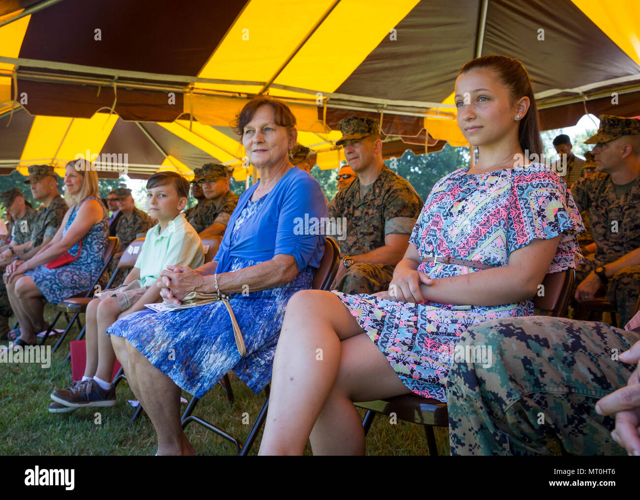 Attendees sit during the playing of the national anthem at a change of