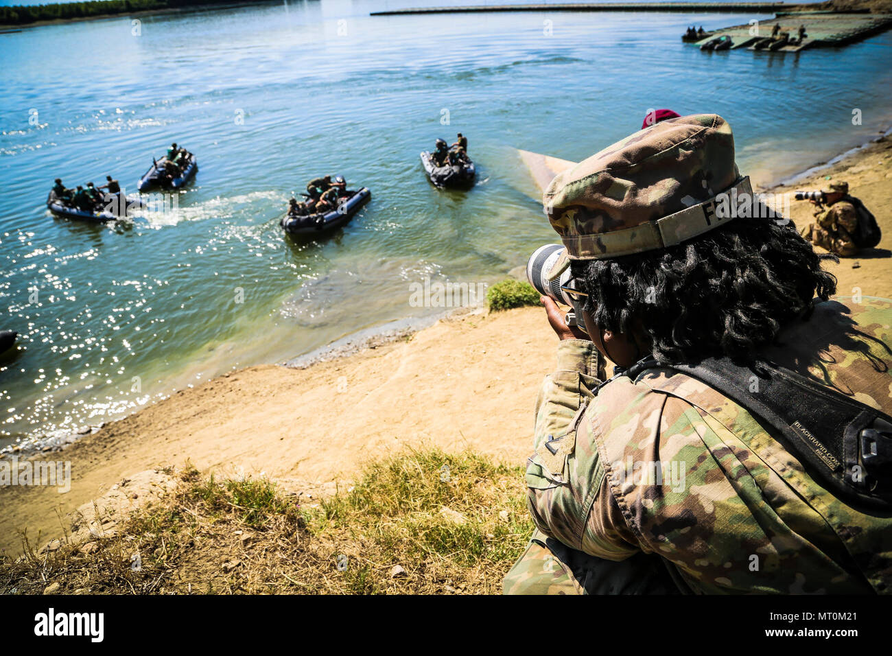 U.S. Army Pfc. Shekinah Frye, photographer assigned to 55th Signal Company (Combat Camera), documents a river crossing exercise during Saber Guardian 17 over the Danube River, Bordusani, Romania, July 15, 2017. Saber Guardian is a U.S. Army Europe-led multinational exercise that spans across Bulgaria, Hungary and Romania with more than 25,000 service members from 22 allied and partner nations. (U.S. Army photo by Staff Sgt. Timothy Villareal/Released) Stock Photo