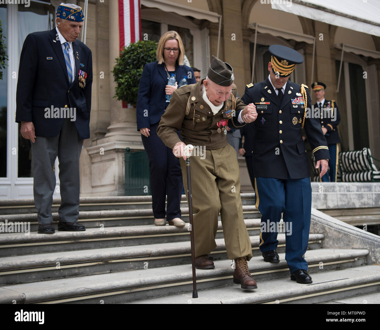 Army Lt. Col. Jessie Brewster, Aide de Camp to Marine Corps Gen. Joseph F. Dunford Jr., chairman of the Joint Chiefs of escorts a World War 2 veteran to his seat,