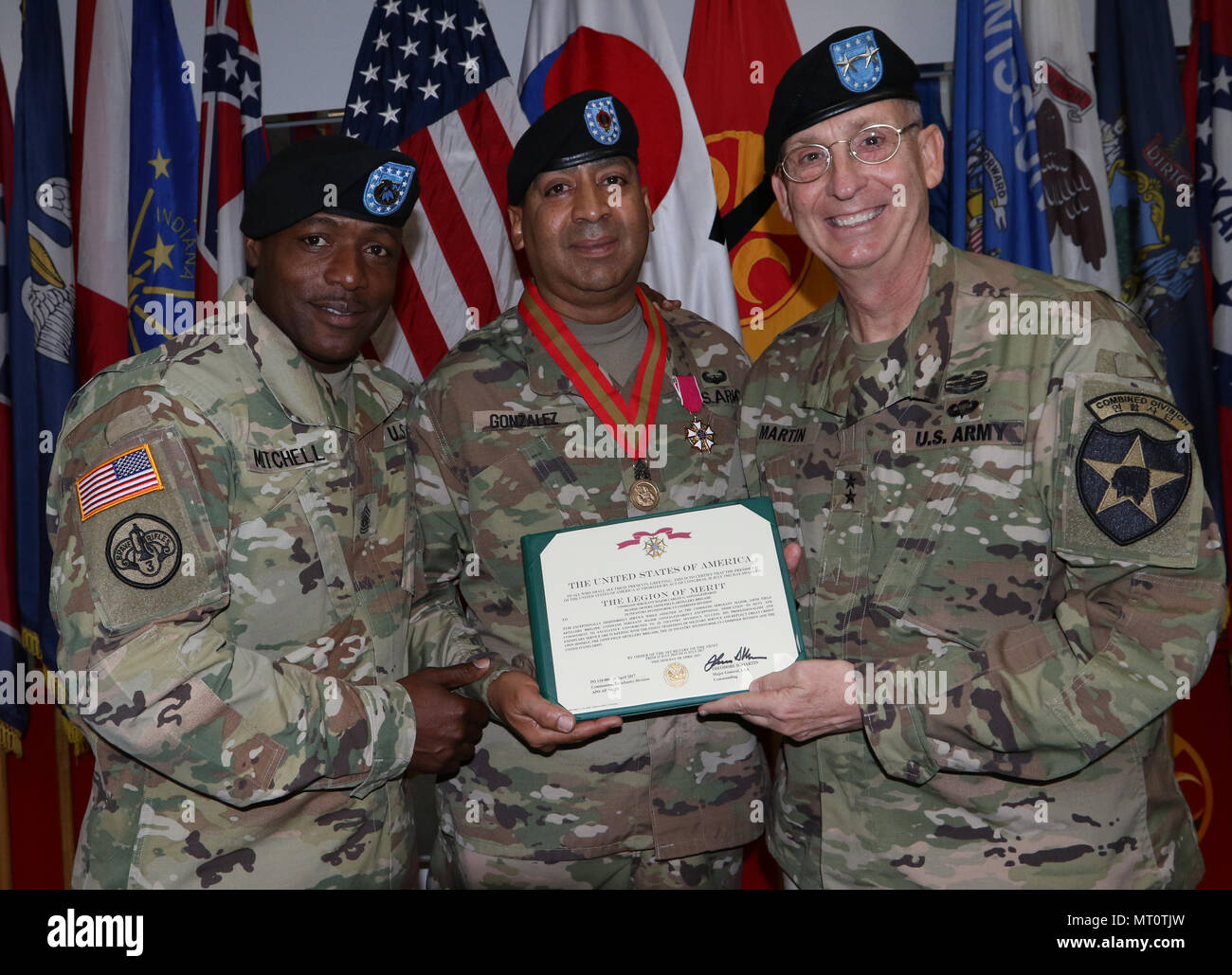 Maj. Gen. Theodore D. Martin, the 2nd Infantry Division/ROK-US Combined Division commander, and Command Sgt. Maj. Edward W. Mitchell, the 2nd Infantry Division/ROK-US Combined Division command sergeant major, presents the United States of American Legion of Merit Award to outgoing 210th Field Artillery Brigade command sergeant major, Command Sgt. Maj. Carlos G. Gonzalez-Pabon, at Carey Gym, Camp Casey, South Korea, July 12, 2017. Gonzalez-Pabon earned the award for his contributions to 210th FA Bde. and 2ID while serving as the brigade command sergeant major from July 2015 to July 2017. (U.S.  Stock Photo