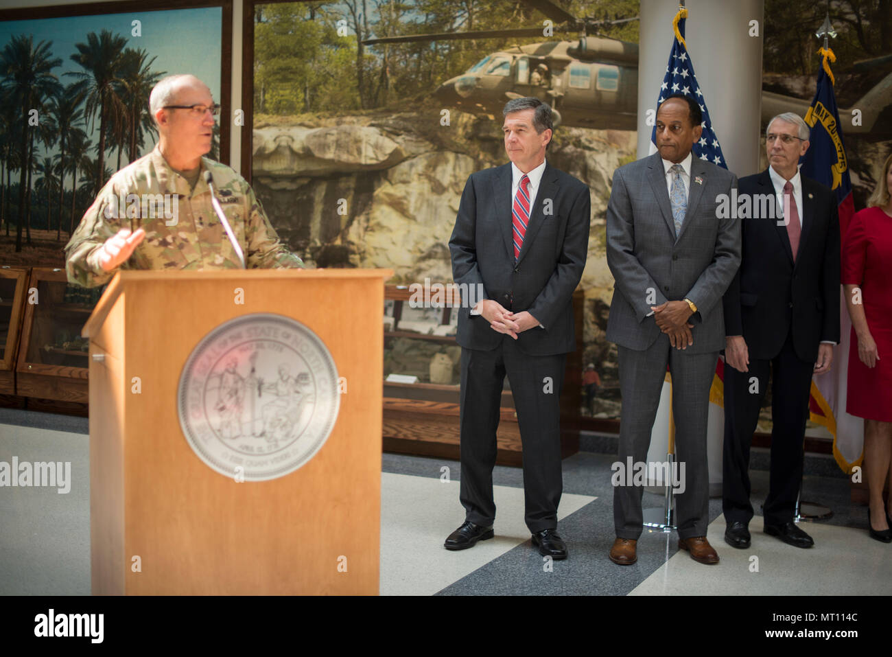 RALEIGH, N.C. - North Carolina Gov. Roy Cooper signs into law three bills expanding the rights and protections of Guardsmen at Joint Force Headquarters in Raleigh, N.C., July 21, 2017. These bills protect soldiers and airmen while attending North Carolina universities and colleges while on state active duty, Guardsmen re-employment rights and authorization for currently serving and retirees to purchase from Correction Enterprises. (U.S. Army National Guard photo by Sgt. Lisa Vines) Stock Photo