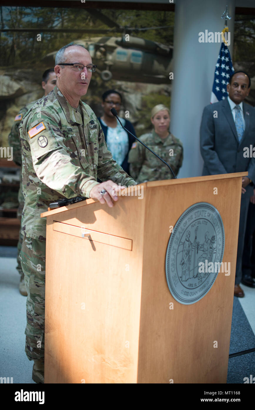 RALEIGH, N.C. - North Carolina Gov. Roy Cooper signs into law three bills expanding the rights and protections of Guardsmen at Joint Force Headquarters in Raleigh, N.C., July 21, 2017. These bills protect soldiers and airmen while attending North Carolina universities and colleges while on state active duty, Guardsmen re-employment rights and authorization for currently serving and retirees to purchase from Correction Enterprises. (U.S. Army National Guard photo by Sgt. Lisa Vines) Stock Photo