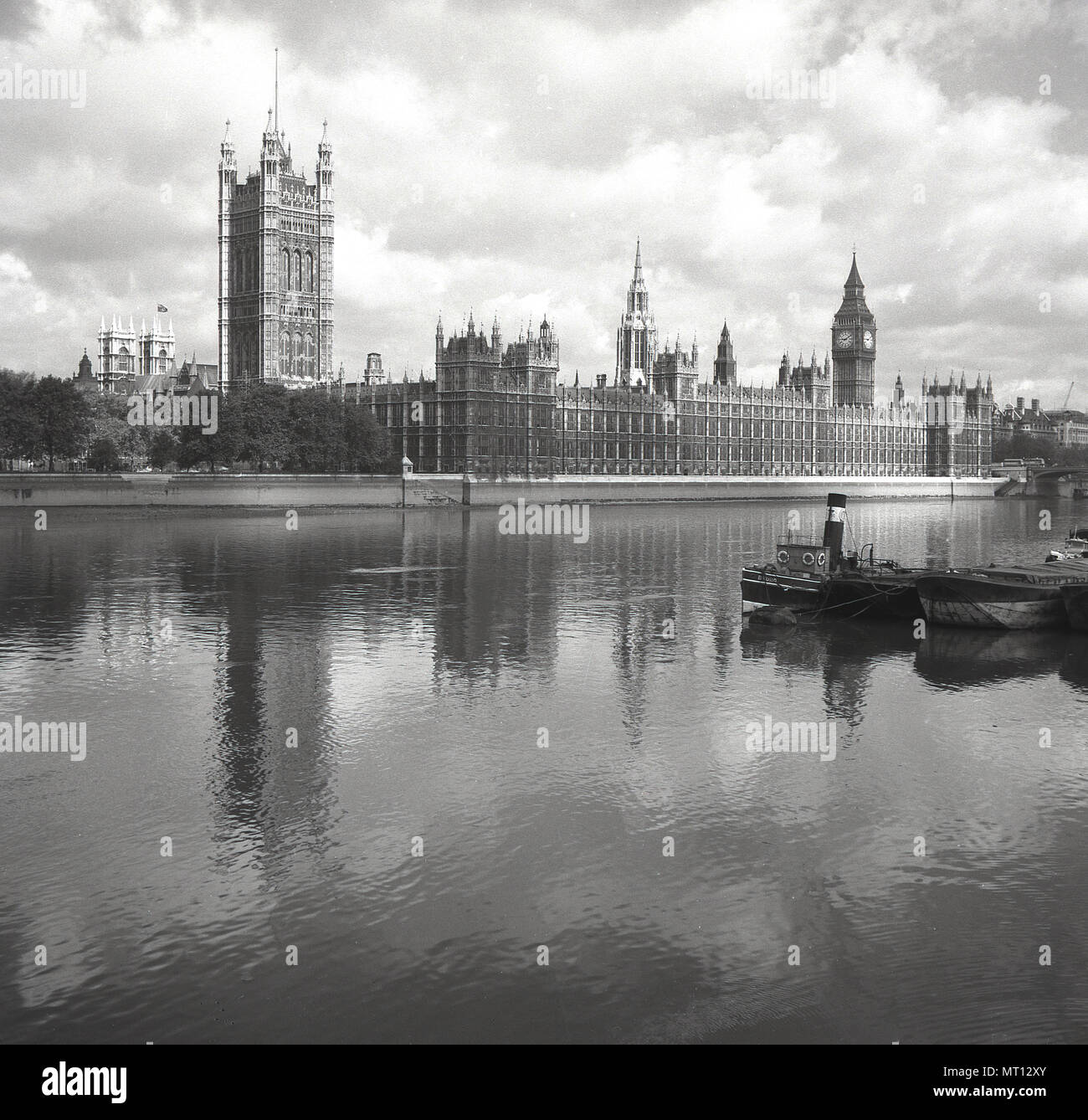 1950s, historical, view from the south of the river across the Thames, London, to the iconic buildings of the Palace of Westminster, meeting place of the UK Government. At the palace are the two Houses of  the UK Parliament, the House of Commons and the House of Lords. Stock Photo