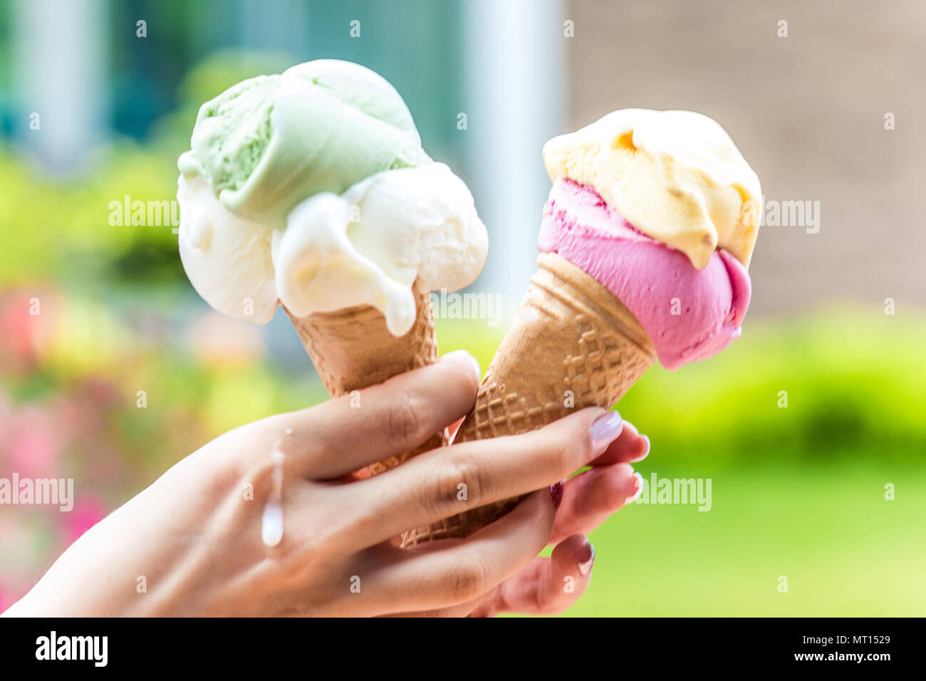 Two horns with ice cream in hot weather in a girl's hand Stock Photo