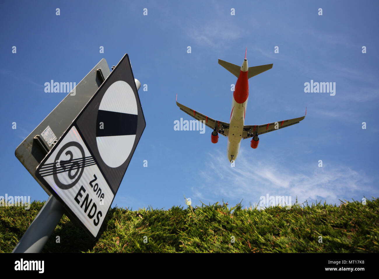 easyjet airbus a320-214 OE-IVM passes over a national speed limit sign as it flies over the road at the end of the runway at Edinburgh airport Stock Photo