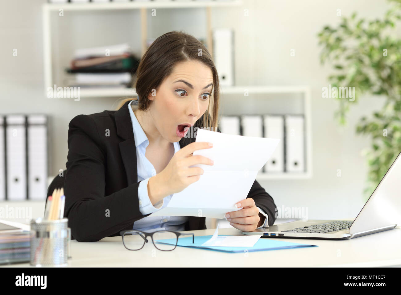 Amazed office worker reading good news a letter Stock Photo