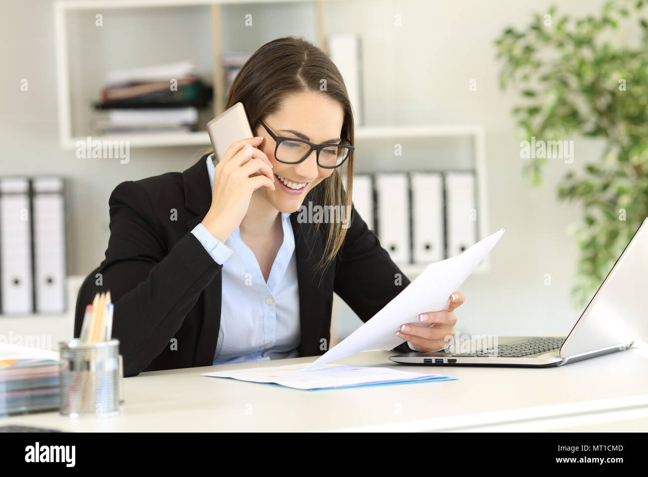 Happy customer calling support service about a paper document at office Stock Photo