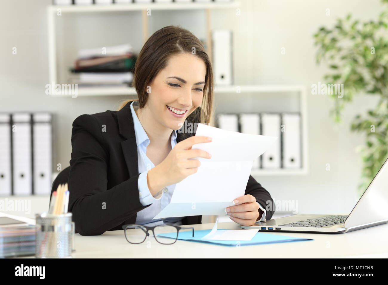 Happy office worker reading news a paper letter Stock Photo