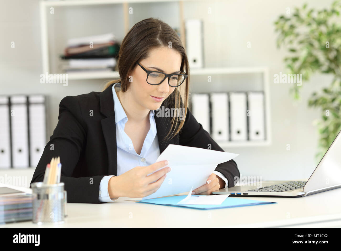 Relaxed office worker reading news a letter on a desktop Stock Photo