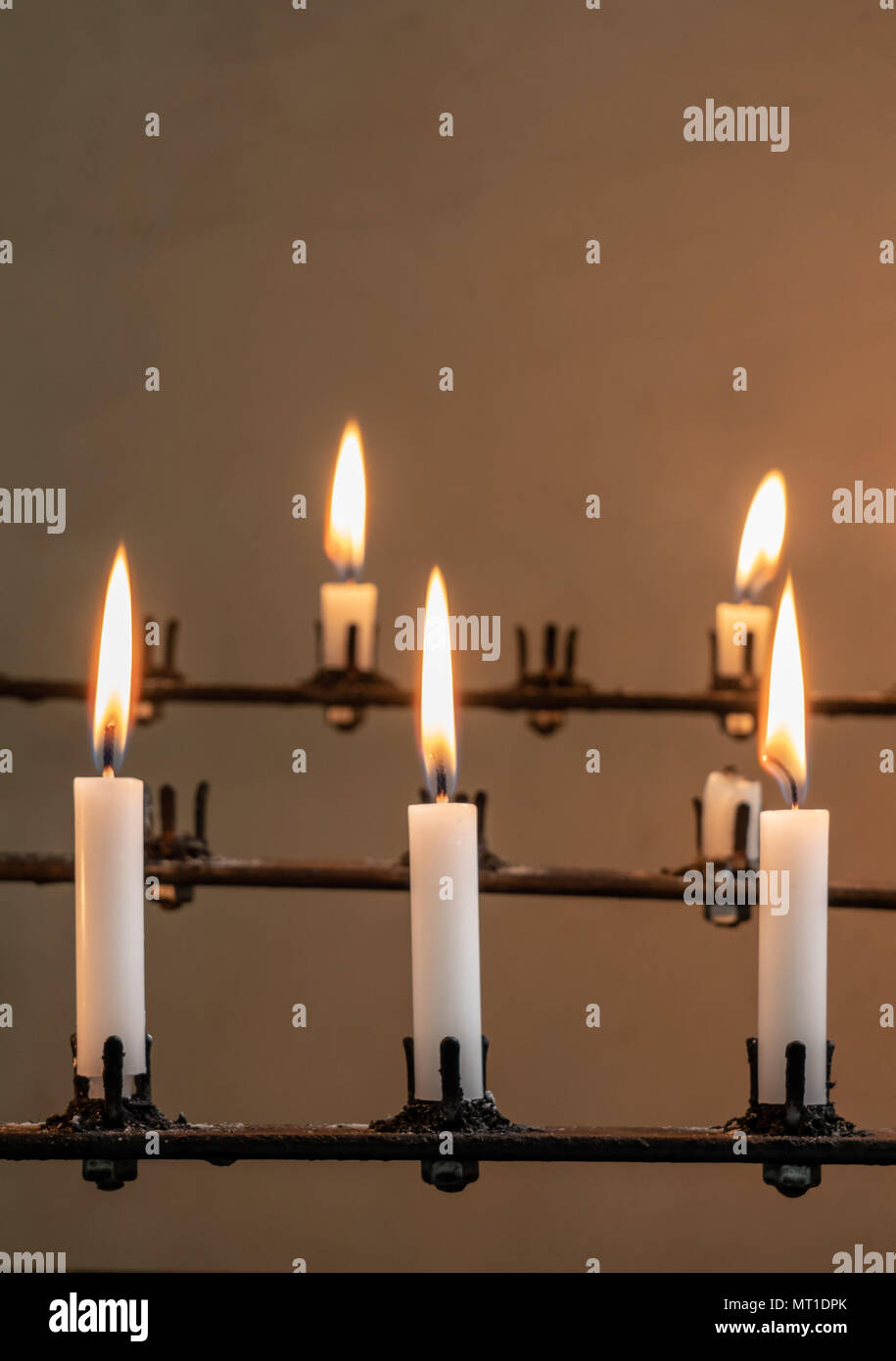 Stand of burning prayer candles in old church Stock Photo Alamy