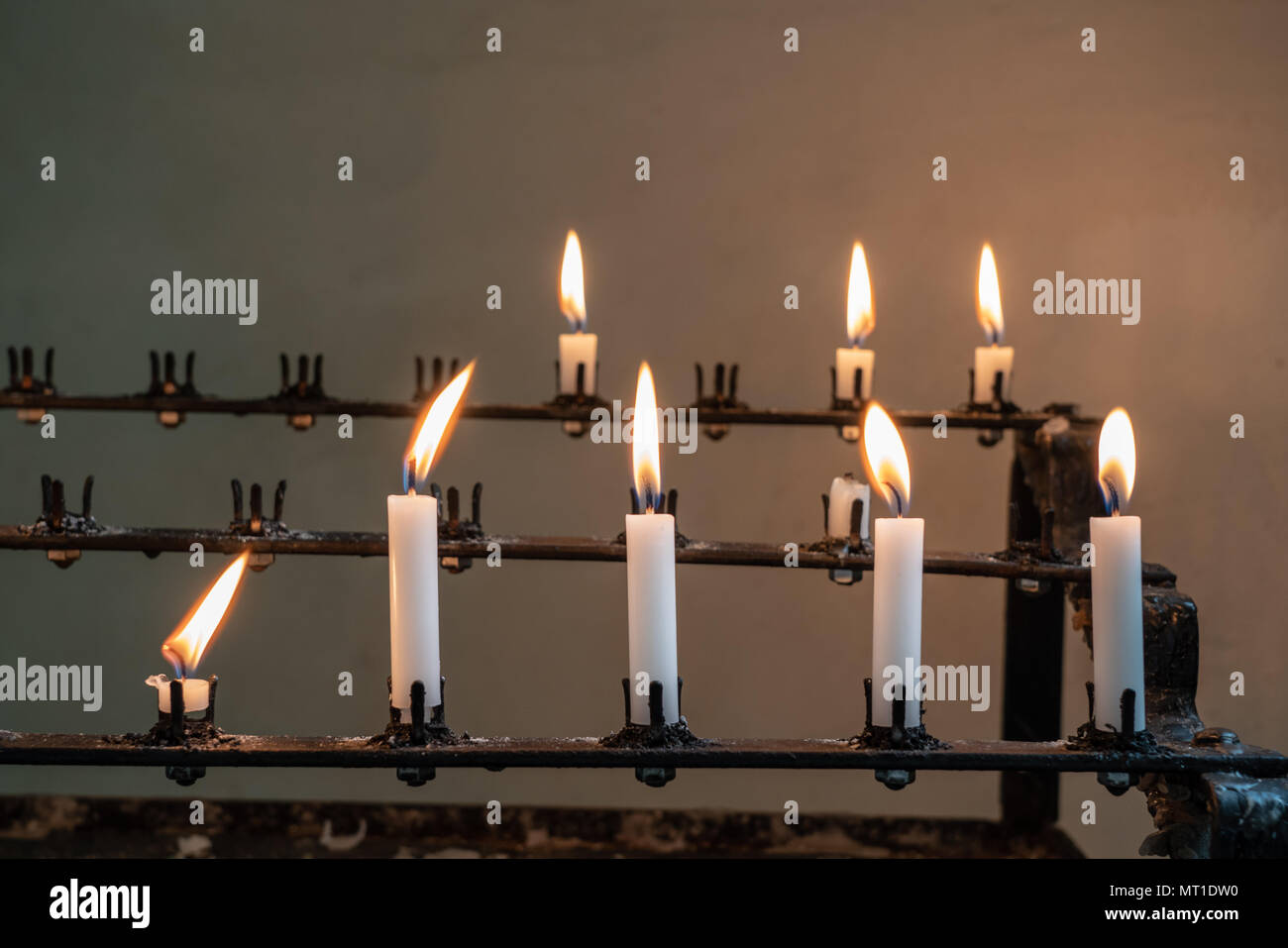 Stand of burning prayer candles in old church Stock Photo Alamy