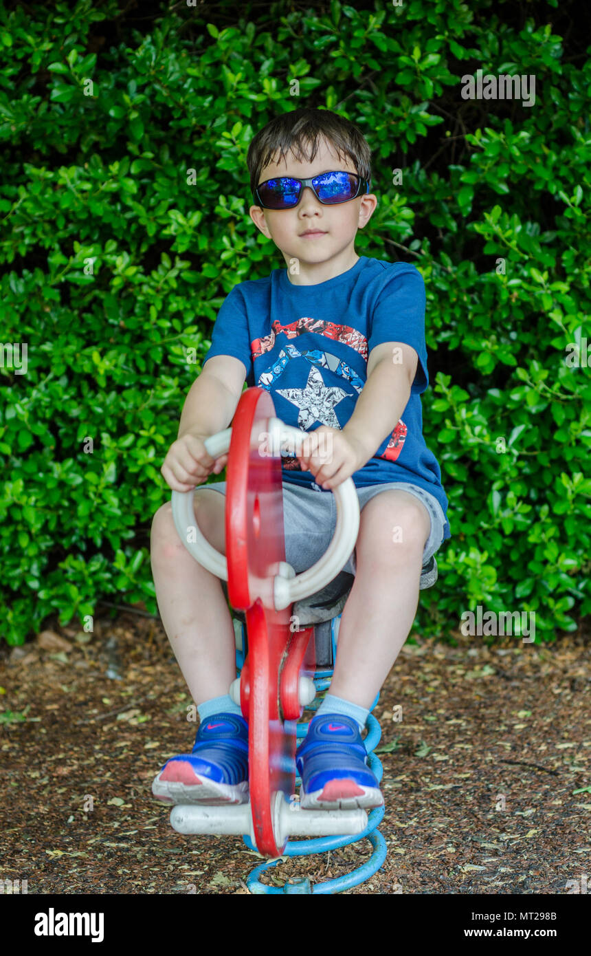 A young boy playing in a children's playground Stock Photo - Alamy