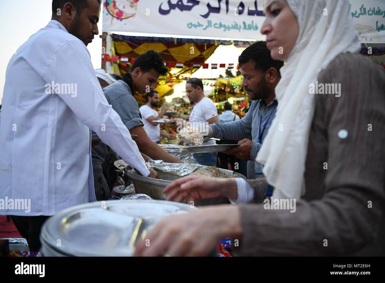 Cairo, Egypt. 27th May, 2018. People prepare the iftar meal during a charity event in Cairo, Egypt, on May 27, 2018. Dozens of Chinese companies on Sunday sent hundreds of food boxes to the needy people and held a charity iftar table in Cairo's Maadi district, sharing the joy of Egyptians during the holy month of Ramadan. Credit: Wu Huiwo/Xinhua/Alamy Live News Stock Photo