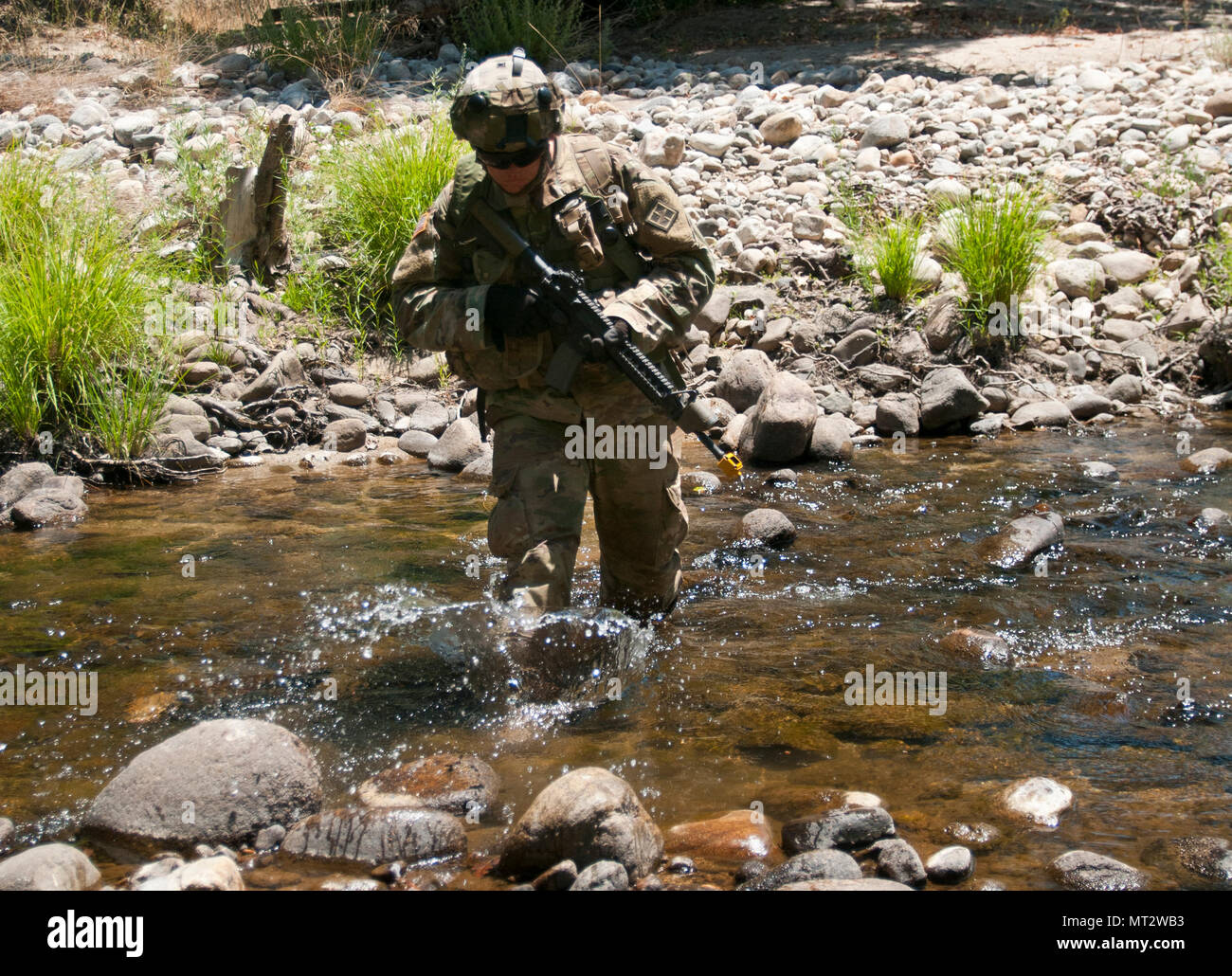 Pfc. Austin Broadway crosses a stream while maneuvering to an observation post near the 718th Engineer Company's command post during training on Fort Hunter Liggett, Calif., on July 19, 2017. The 718th is an Army Early Response Force unit, capable of deploying within 30 days of notification to support any combatant command in the world. Nearly 5,400 service members from the U.S. Army Reserve Command, U.S. Army, Army National Guard, U.S. Navy, and Canadian Armed Forces are training at Fort Hunter Liggett as part of the 84th Training Command’s CSTX 91-17-03 and ARMEDCOM’s Global Medic; this is a Stock Photo