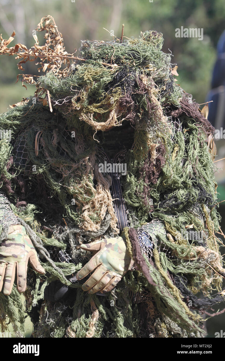 A Mexican soldier looks over his ghillie suit before the beginning of a stalk-and-shoot event July 20, 2017 during Fuerzas Comando in Ñu Guazú , Paraguay. The objective of Fuerzas Comando is to enhance multinational and regional cooperation. (U.S. Army photo by Spc. Tonya Deardorf/Released) Stock Photo