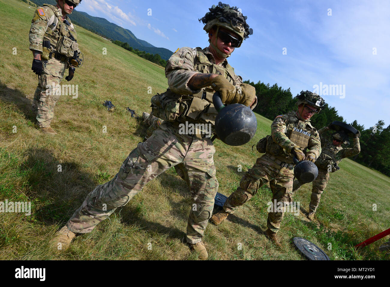 U.S. Army paratroopers assigned to 2nd Battalion, 503rd Infantry Regiment,  173rd Airborne Brigade, swing a kettlebell to stress themselves before a  live-fire exercise as part of Exercise Rock Knight at Bac Range