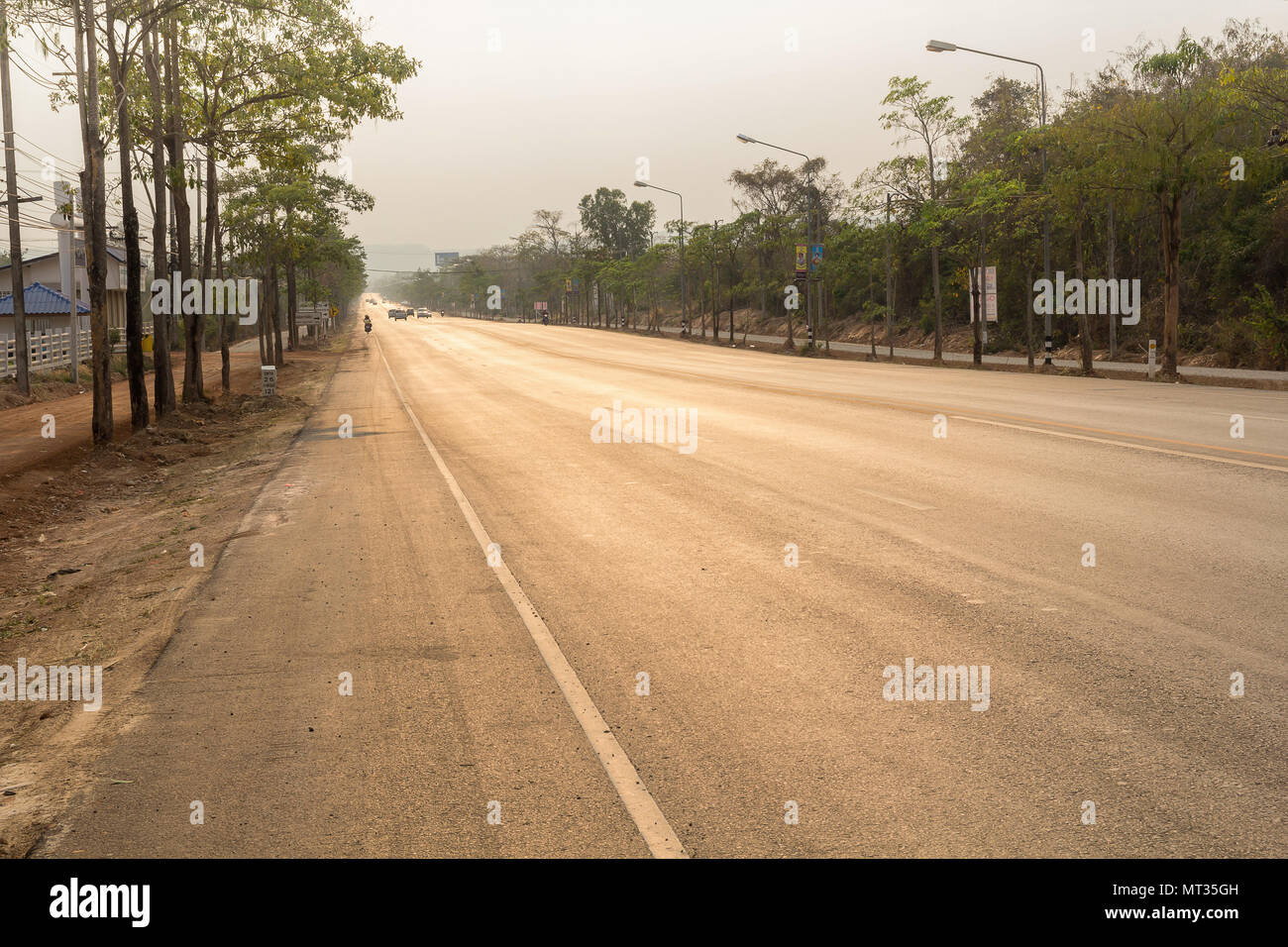 road up hill to the mountain top at at sunny sunset. Stock Photo