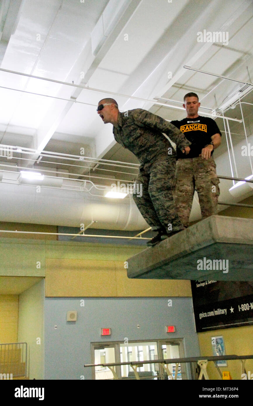 An Airmen yells “Ranger!” and jumps off a diving board with blackedout