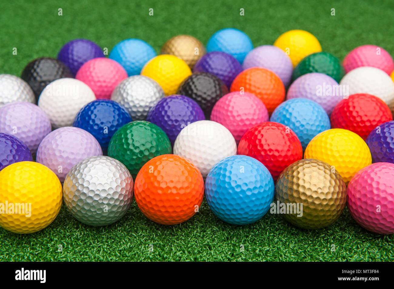Colorful miniature golf balls on green synthetic grass Stock Photo