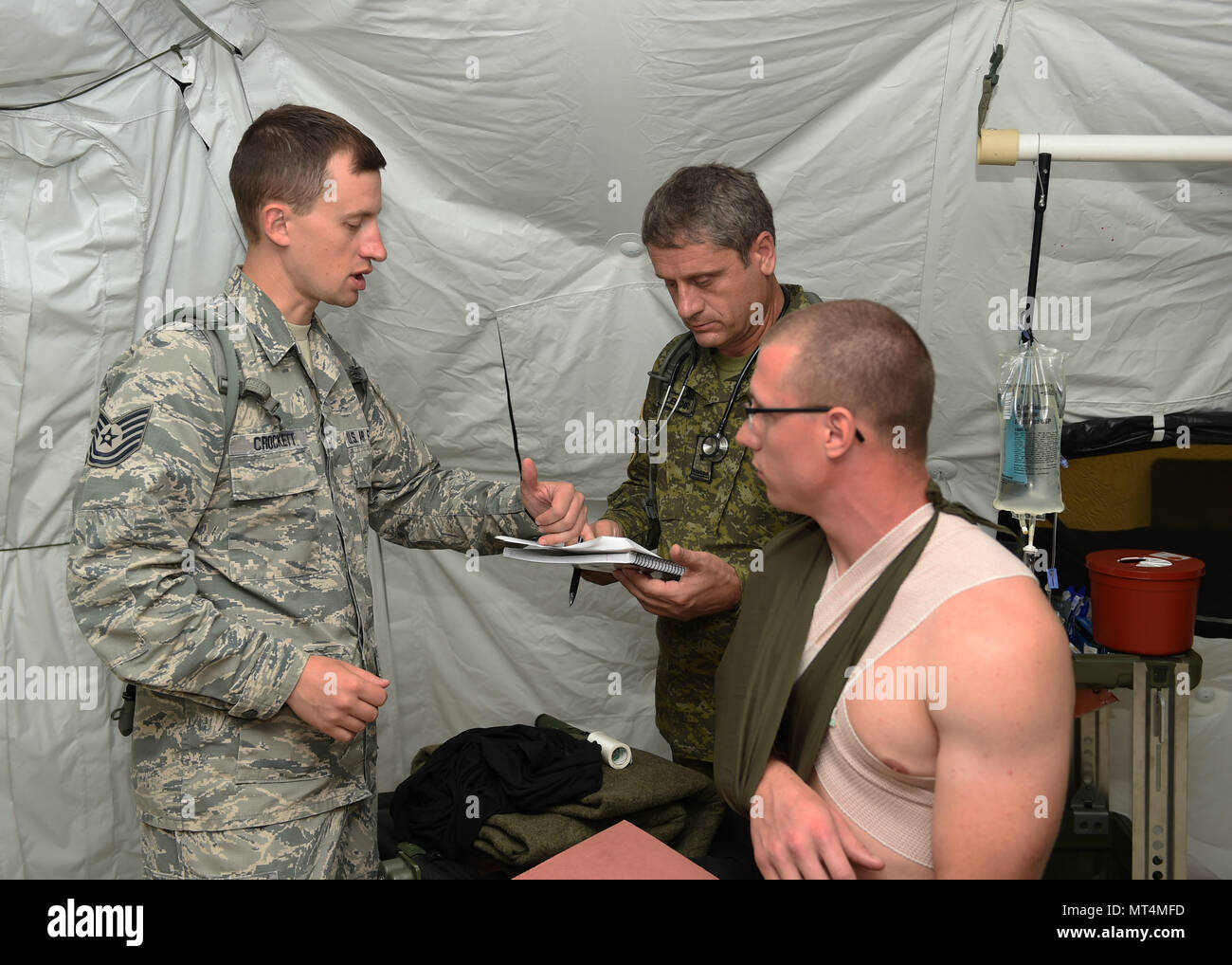 Tech. Sgt. Davy Crockett, 132d Medical Group nursing NCOIC, reviews patient  notes with Maj. Enver Bequiri , a doctor in the Kosovo Security Force, July  24, 2017, at Camp Dodge in Johnston