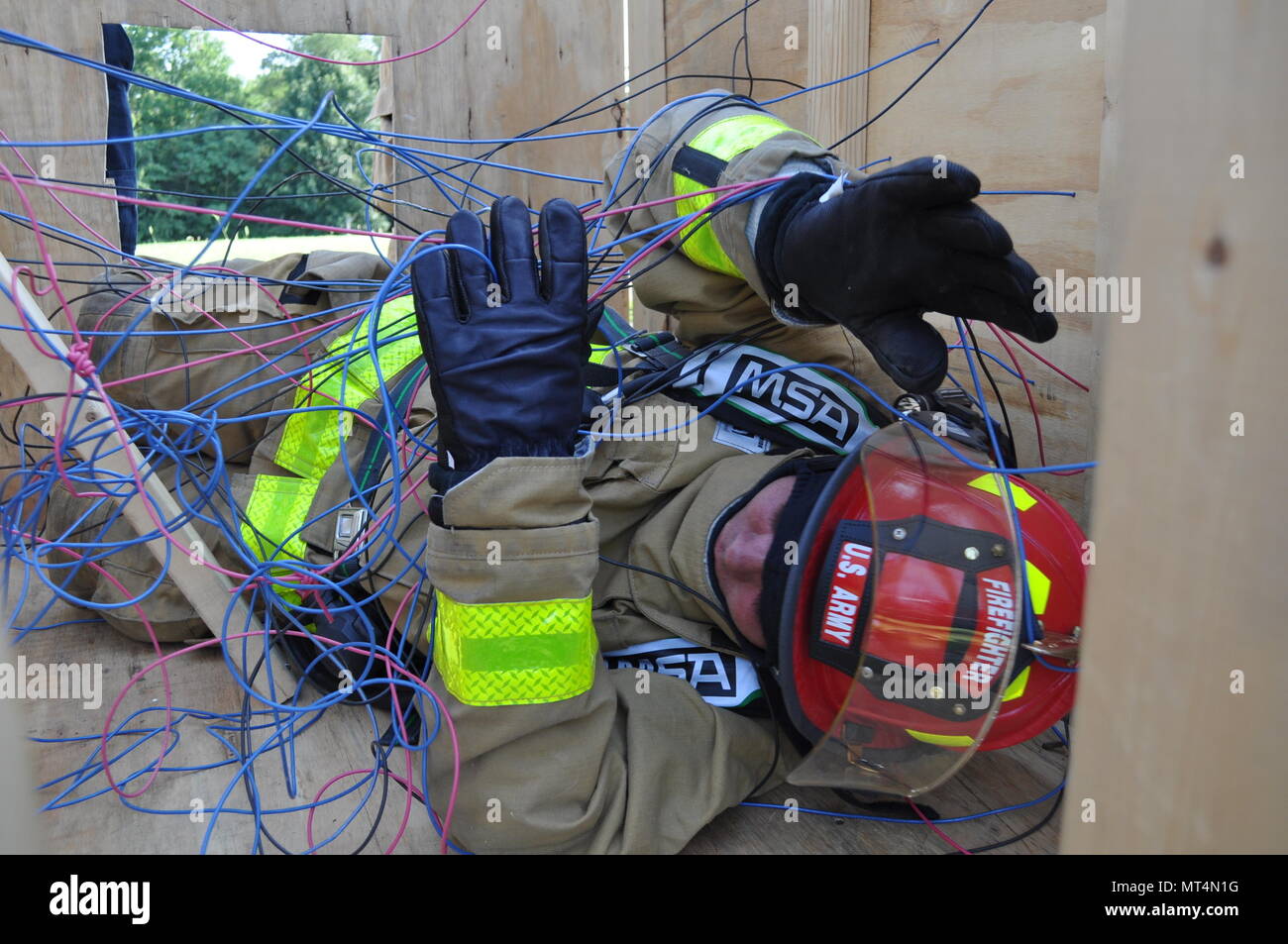 A Soldier from the 802nd Ordnance Co. performs a firefighting training operation at Crane Army Ammunition Activity. The exercise involves simulations of real-life situations, such as navigating through confined spaces and tangled electrical wiring with a limited field of vision. The Soldiers are conducting their two-week annual training at Crane receiving hands-on education in ammunition handling, mechanics and firefighting skills. Stock Photo