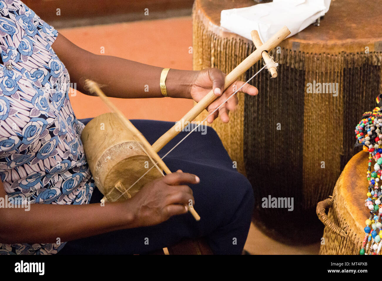 Kampala, Uganda. 15 May 2017. A Ugandan woman playing a traditional Ugandan instrument, the Endingidi (also ndingidi, or Adigirgi): Fiddle – String Stock Photo
