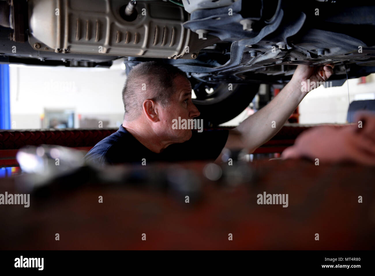 Thomas Johnson, 19th Force Support Squadron Auto Hobby Shop lead mechanic, finishes draining the oil of a customer’s car June 9, 2017, at Little Rock Air Force Base, Ark. Johnson uses a variety of tools to help make draining oil from cars easier. (U.S. Air Force photo by Airman Rhett Isbell) Stock Photo