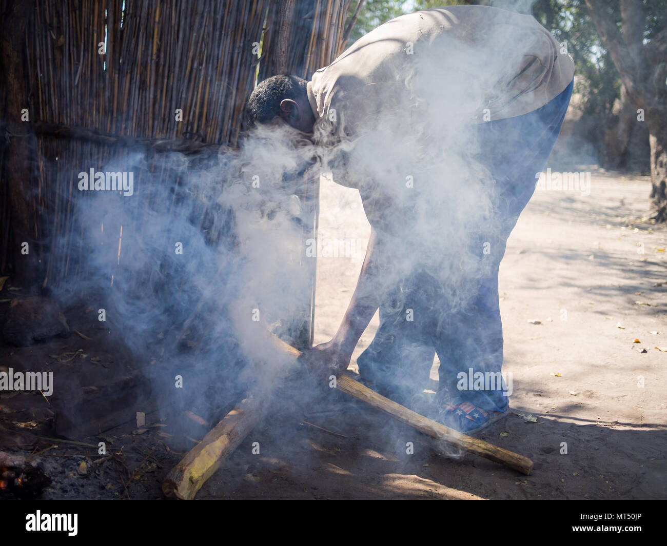Luzibalule, Namibia - August 13, 2015: Unidentified African man operating traditional forge at Lizauli Traditional Village Stock Photo