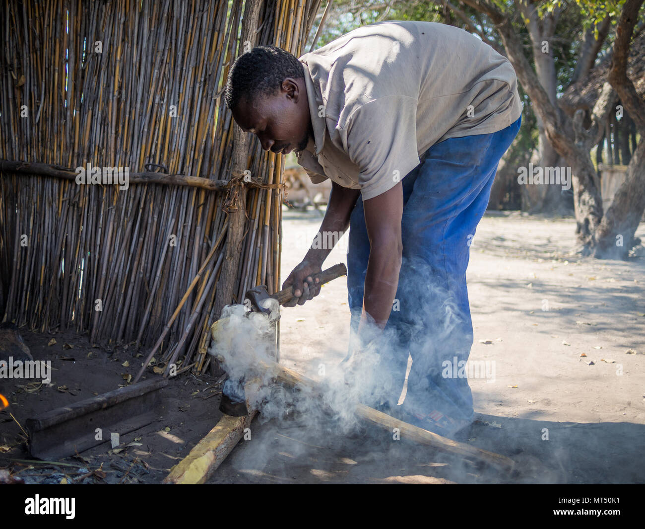 Luzibalule, Namibia - August 13, 2015: Unidentified African man operating traditional forge at Lizauli Traditional Village Stock Photo