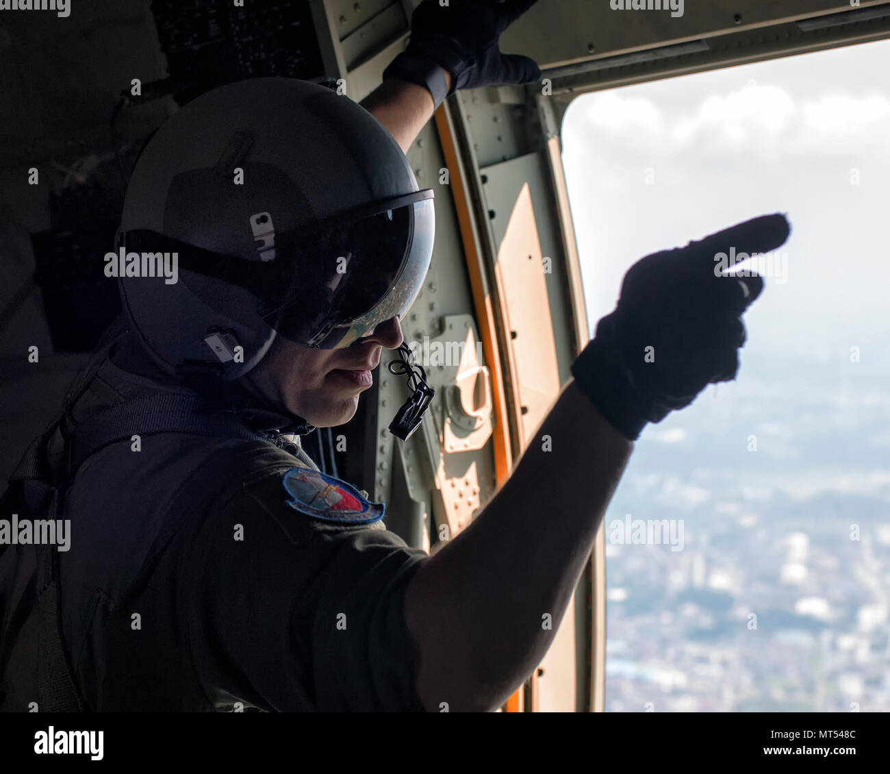 Tech. Sgt. Jonathan Lange, 374th Operations Support Squadron C-130J loadmaster, gives point commands prior to personnel jump onto the Yokota Air Base, Japan, July 28, 2017, during a training mission. The training not only allowed survival, evasion, resistance and escape specialists to practice jumping, but it also allowed the Yokota aircrews to practice personnel drops and maintaining their qualifications. (U.S. Air Force photo by Yasuo Osakabe) Stock Photo
