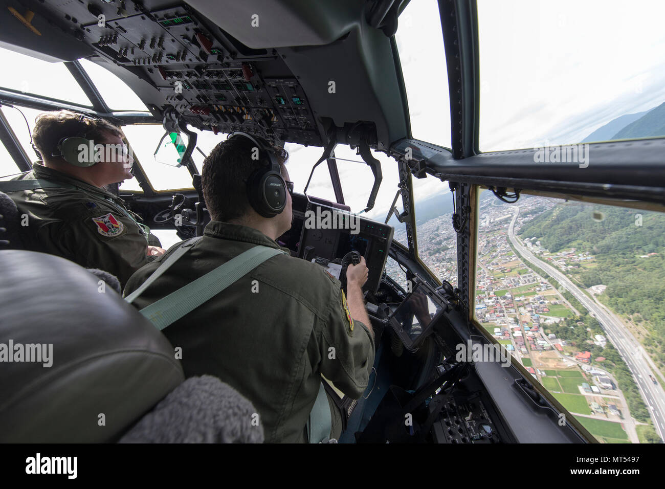 Lt. Col. Tyler Kern, 36th Airlift Squadron director of operations, and Maj. Scott Vander Ploeg, 36th Airlift Squadron assistant director of operations, fly over Yamanashi prefecture, Japan, July 28, 2017. The 36th AS crew members work daily to deliver airlift priorities to a larger area than any other U.S. base in the world. (U.S. Air Force photo by Yasuo Osakabe) Stock Photo