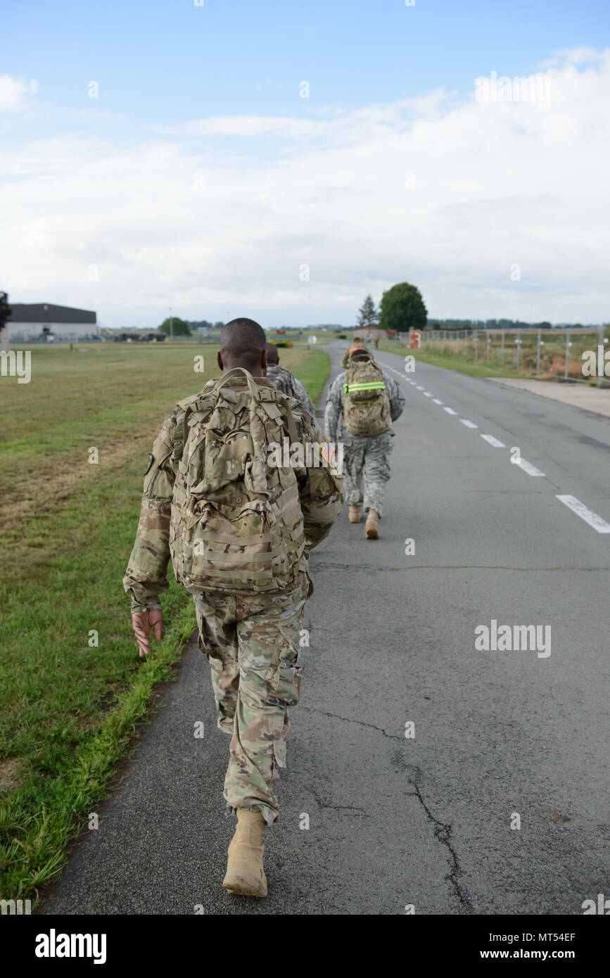 U.S. Army Lt. Col. Frank E. Jefferson Jr. walks with Soldiers assigned to Headquarters and Headquarters Company, Allied Forces North Battalion as they take care of their physical condition by performing a 9-mile ruck march on Chièvres air Base, Belgium, July 20, 2017. (U.S. Army photo by Visual Information Specialist Pierre-Etienne Courtejoie) Stock Photo
