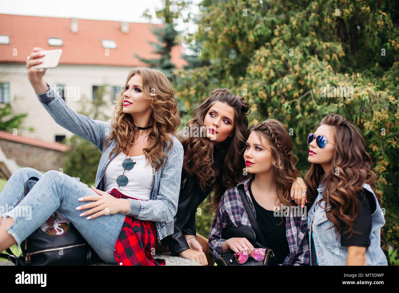 Fashionable ladies with hairstyle taking selfie outdoors. Stock Photo