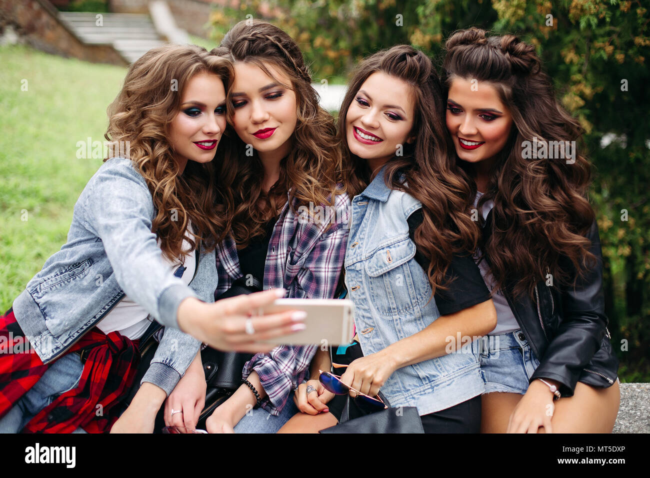 Fashionable ladies with hairstyle taking selfie outdoors. Stock Photo