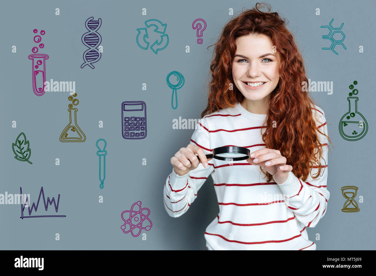 Smiling teacher looking friendly while holding a magnifying glass Stock ...