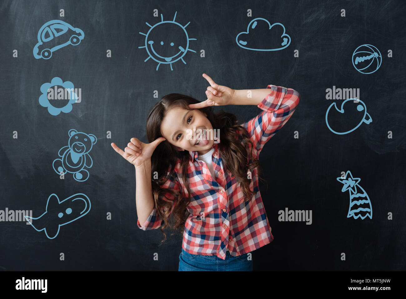 Positive child making faces while having fun at the party Stock Photo