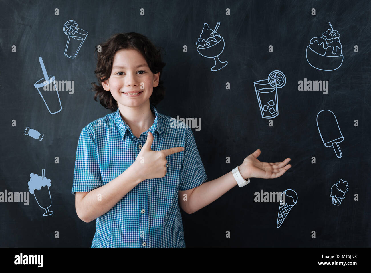 Curly boy smiling and offering cold drinks and ice cream Stock Photo