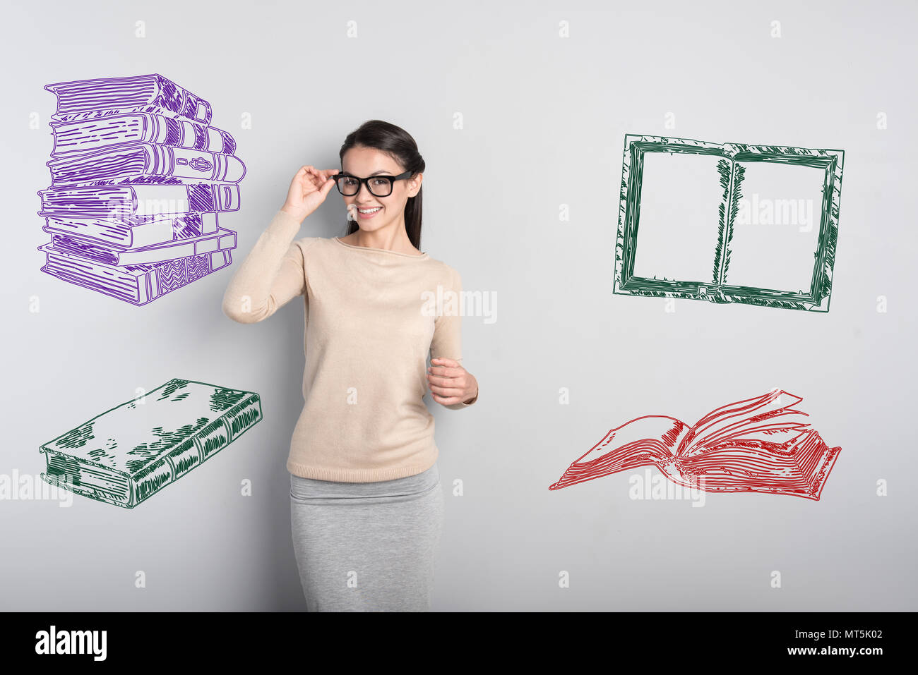 Smiling teacher touching her glasses and looking happy Stock Photo - Alamy