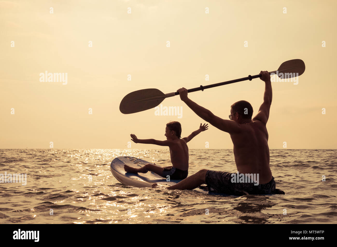Father and baby son playing on the beach at the day time. People having fun outdoors. Concept of summer vacation and friendly family. Stock Photo